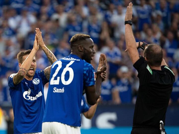 Schalkes Sane (M) und Burgstaller (l) beschweren sich bei Schiedsrichter Fritz über ein nicht gegebenes Handspiel.