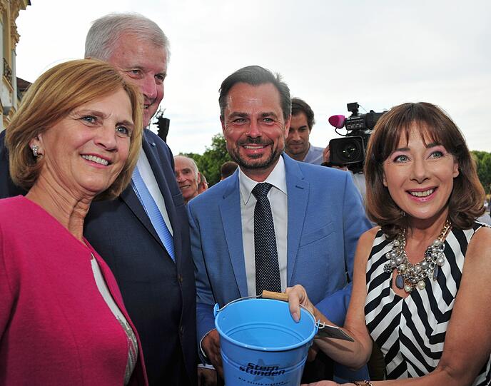 Horst Seehofer und seine Frau Karin kaufen von den Moderatoren Michael Spoerer und Sabine Sauer beim Sommerempfang  Lose. Mit ihrer Teilnahme unterstützen die Gäste einen wohltätigen Zweck.