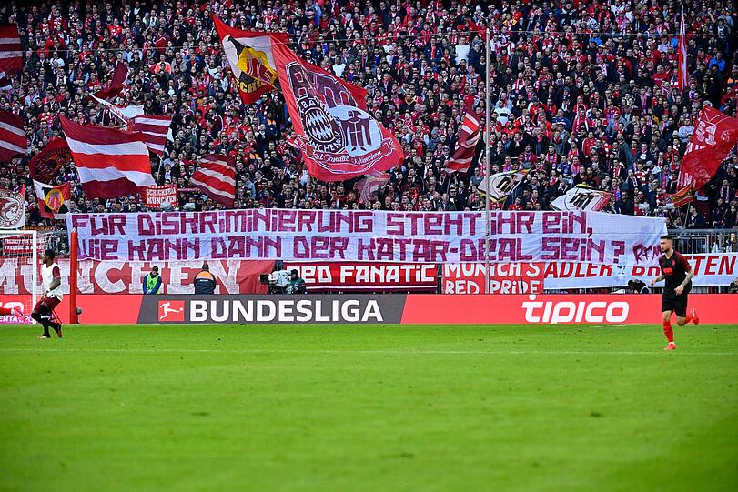 Fans des FC Bayern München protestieren mit einem Plakat gegen die Partnerschaft des Klubs mit dem Emirat Katar.