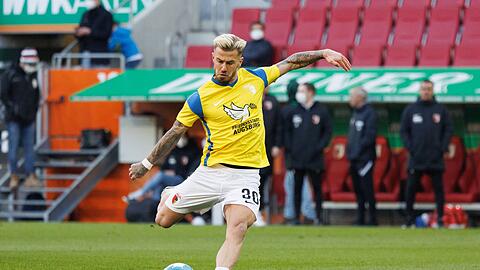 Niklas Dorsch in einem Trikot in den Landesfarben der Ukraine und mit dem Schriftzug „Friedensstadt Augsburg“.