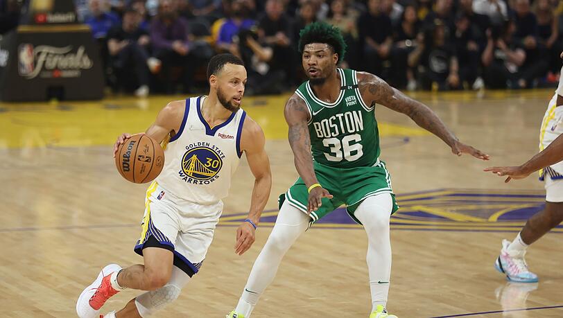 Stephen Curry (l), Guard der Golden State Warriors, zieht zum Korb gegen Marcus Smart, Guard der Boston Celtics.