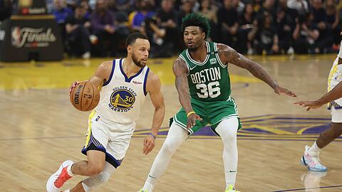 Stephen Curry (l), Guard der Golden State Warriors, zieht zum Korb gegen Marcus Smart, Guard der Boston Celtics.