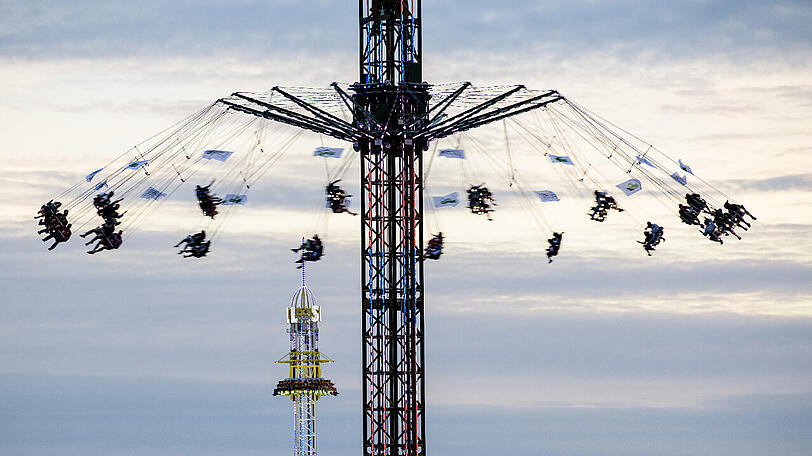 Das Riesen-Kettenkarussell dreht sich vor dem Fallturm auf dem Oktoberfest auf der Theresienwiese.