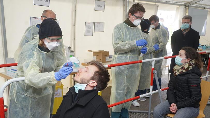 Wissenschaftsminister Bernd Sibler (CSU, hinten rechts) beobachtet, wie in der neuen Teststation Abstriche genommen werden. Diese werden in der Nase genommen. Das gilt als angenehmer für die Testpersonen und liefert auch zuverlässigere Ergebnisse.