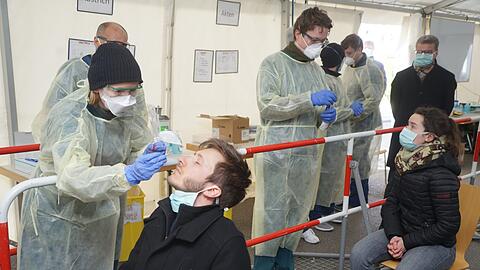 Wissenschaftsminister Bernd Sibler (CSU, hinten rechts) beobachtet, wie in der neuen Teststation Abstriche genommen werden. Diese werden in der Nase genommen. Das gilt als angenehmer für die Testpersonen und liefert auch zuverlässigere Ergebnisse.