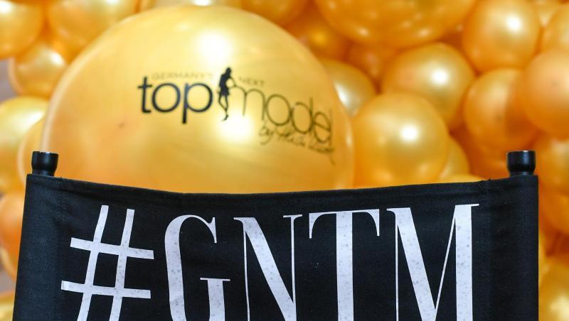 Das Logo der Show "Germany's next Topmodel - by Heidi Klum" steht auf einem Regiestuhl.