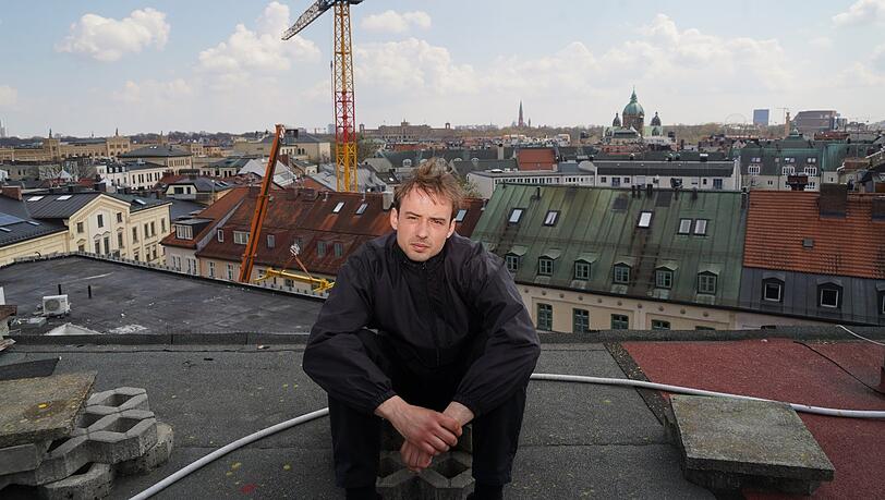 Tape-Artist Dinomaat sitzt auf dem Parkdeck über den Dächern der Stadt. Tape-Artist Dinomaat sitzt auf dem Parkdeck über den Dächern der Stadt.