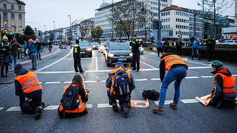 Aktivisten der Klimaschutz-Initiative "Letzte Generation" kleben sich am Stachus mit ihren Händen auf die Straße.