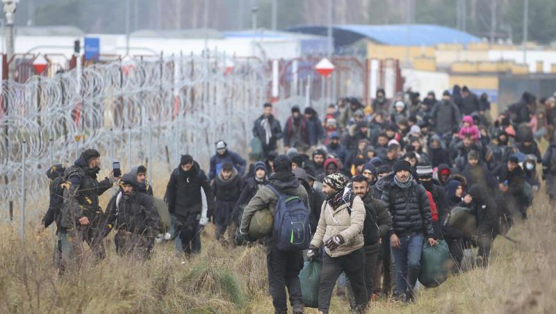 Migranten am Stacheldrahtzaun an der belarussisch-polnischen Grenze.