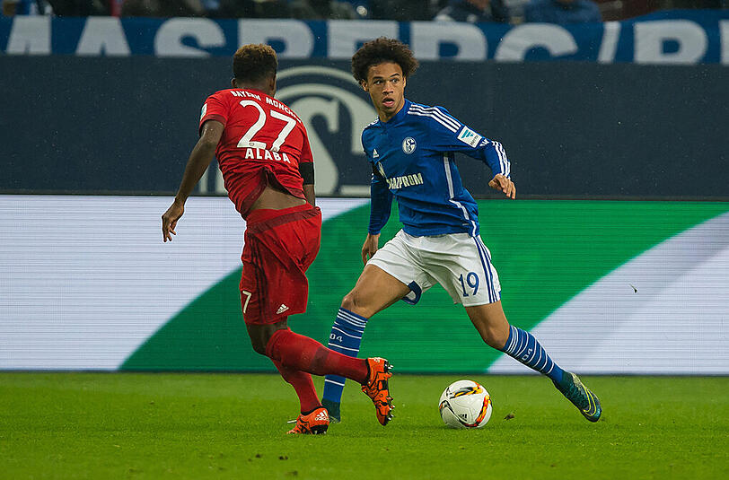David Alaba kämpft im Spiel des FC Bayern gegen Schalke 04 mit Leroy Sane (r) um den Ball. Später musste der Österreicher angeschlagen vom Platz.