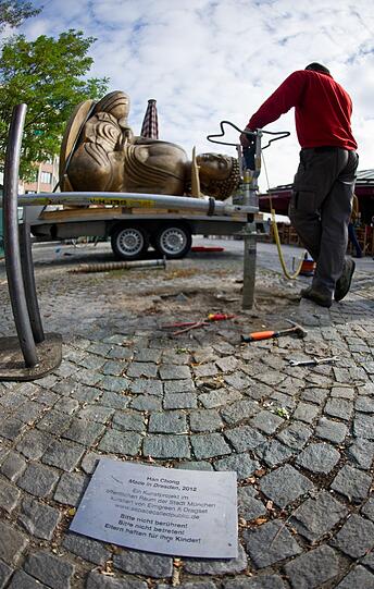 Ende einer Kunstaktion: Der liegende Buddha vom Viktualienmarkt wird abgebaut und auf einem Tieflader festgezurrt.