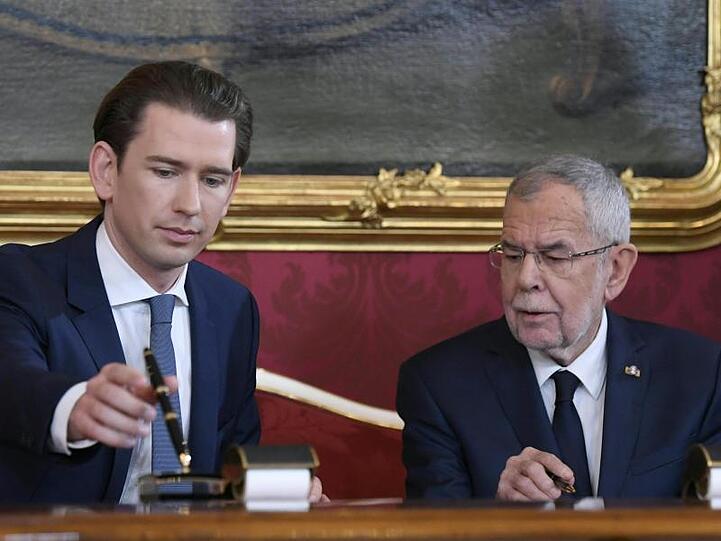 Sebastian Kurz, Bundeskanzler von Österreich, unterzeichnet seine Ernennungsurkunde neben Bundespräsident Alexander Van der Bellen.