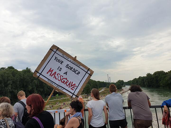 Eine Demonstrantin mit einer Todesanzeige als Mahnplakat.