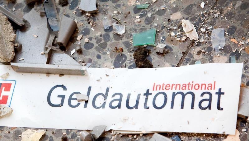 Splitter und ein abgerissenes Schild auf dem Fußboden vor einem gesprengten Geldautomaten. Splitter und ein abgerissenes Schild auf dem Fußboden vor einem gesprengten Geldautomaten.