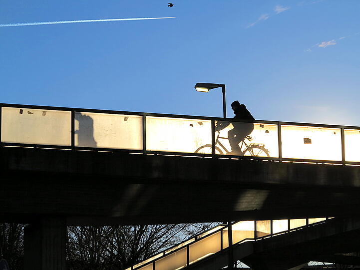 Interessante Schattenspiele: Fußgänger und Radler auf der Neuperlacher Sonnenbrücke.