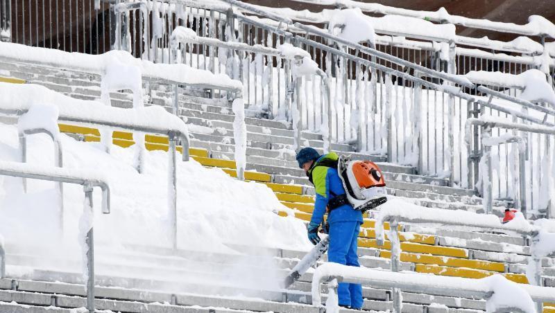 Ein Helfer befreit die Zuschauertribühne in der Chiemgau Arena in Ruhpolding (Bayern) vom Schnee. Foto: Tobias Hase/Archiv Ein Helfer befreit die Zuschauertribühne in der Chiemgau Arena in Ruhpolding (Bayern) vom Schnee. Foto: Tobias Hase/Archiv