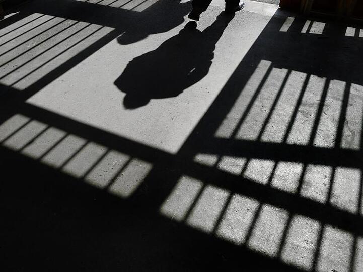 Der Schattenriss eines Mannes ist in der Justizvollzugsanstalt in einer Tür zu sehen. Foto: Felix Kästle/Archivbild