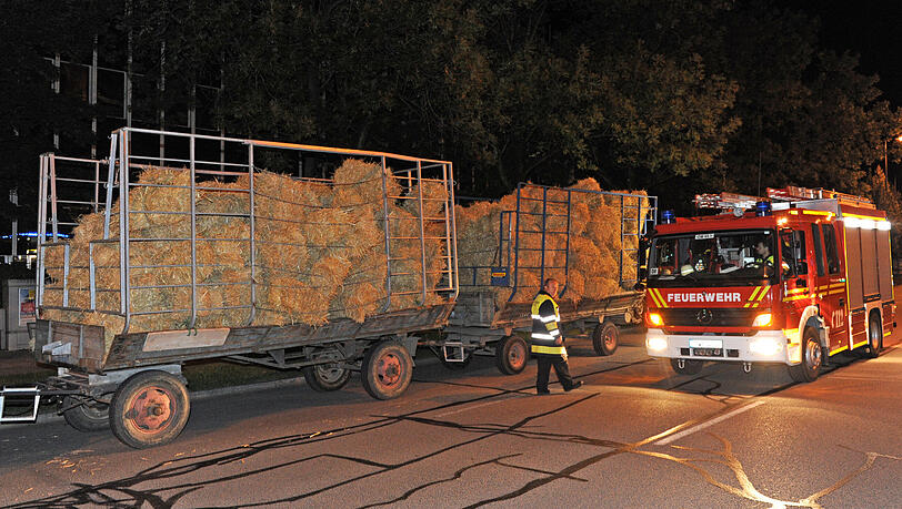 Ein Traktor karrt das Dämmmaterial heran: Stroh.