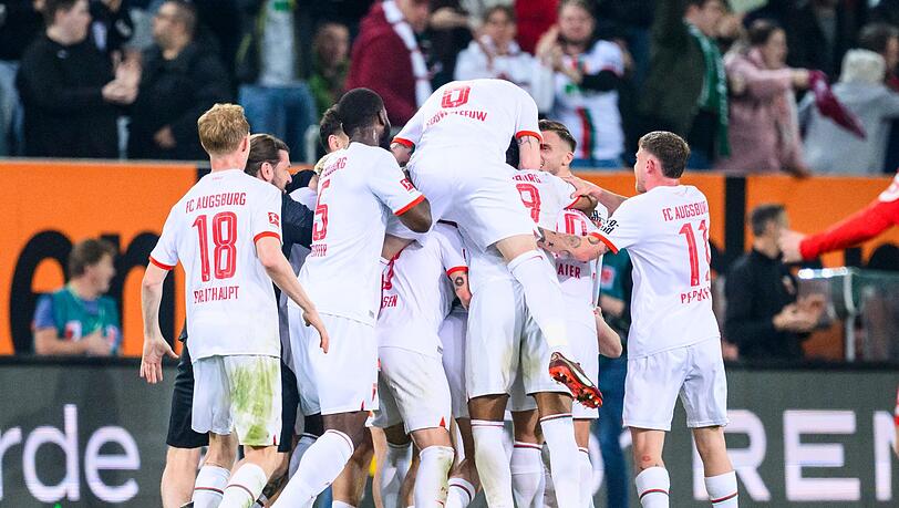 Augsburgs Sven Michel (verdeckt) jubelt nach seinem Tor zum 2:0 mit der Mannschaft.