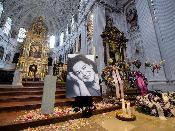 Kerzen, Blumengestecke und ein Bild von Hannelore Elsner stehen bei der Trauerfeier. Foto: Matthias Balk/Archivbild