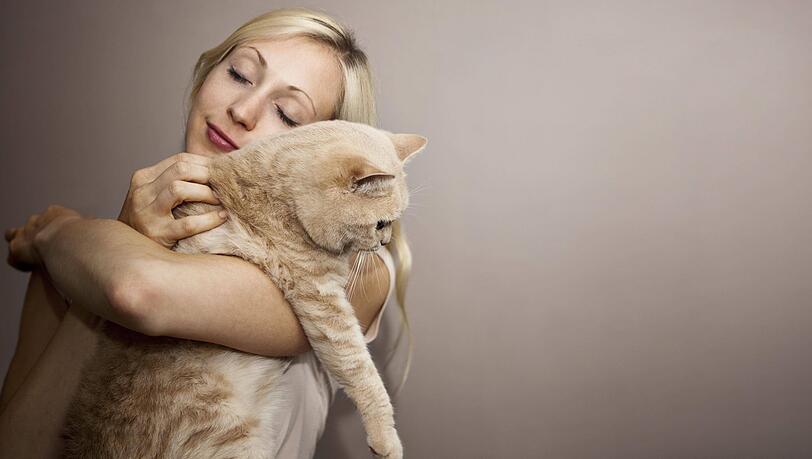 Eine Frau schmust mit ihrer Katze – die typische Haustierbesitzerin, besagt eine Studie. Eine Frau schmust mit ihrer Katze – die typische Haustierbesitzerin, besagt eine Studie.