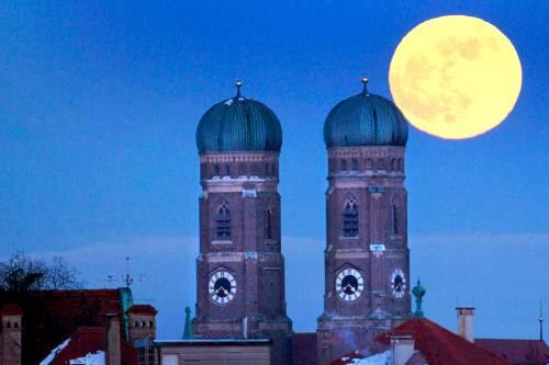 Sieht wunderschön aus - und hilft angeblich auch der Wirtschaft: Der Mond über der Münchner Frauenkriche.