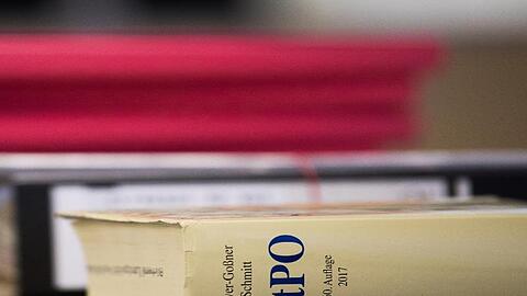 Eine Strafprozessordnung liegt neben Akten auf einem Tisch. Foto: Nicolas Armer/dpa/Symbolbild