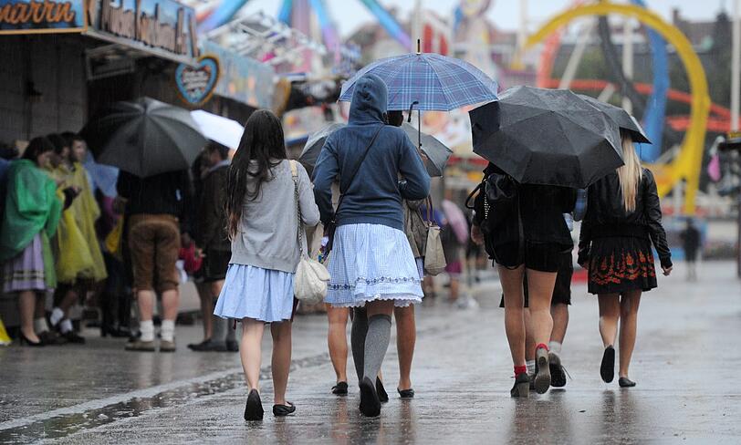 Trotz Sauwetter und Regen warten bereits viele Wiesngänger auf den Wiesnanstich. Der Kampf um den Platz im Bierzelt beginnt schon am frühen Morgen. Die ersten Bilder.