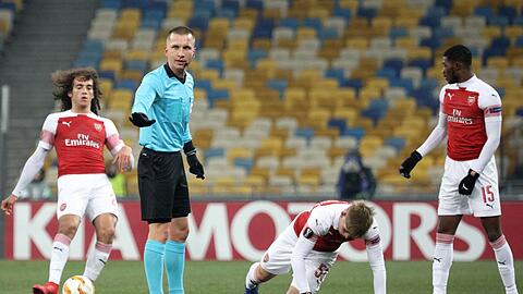Schiedsrichter Bartosz Frankowski (l) gestikuliert neben Stürmer Emile Smith Rowe (M) von FC Arsenal.