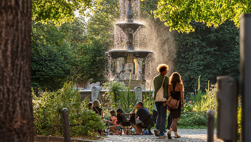 Der Weißenburger Platz an einem Sommerabend. Er liegt im Zentrum des Franzosenviertels im Stadtteil Haidhausen. Hier treffen sich Münchnerinnen und Münchner zum Entspannen und Ratschen.