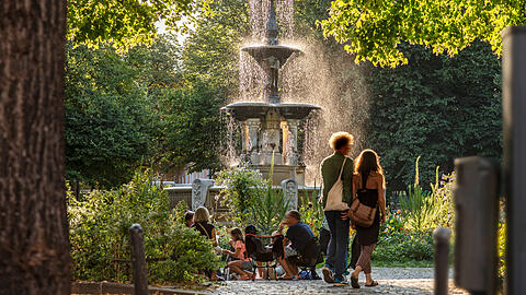 Der Weißenburger Platz an einem Sommerabend. Er liegt im Zentrum des Franzosenviertels im Stadtteil Haidhausen. Hier treffen sich Münchnerinnen und Münchner zum Entspannen und Ratschen.