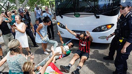 Demonstranten protestierten, w&auml;hrend der Bus mit iranischen Spielerinnen und Mitarbeitern abfuhr.