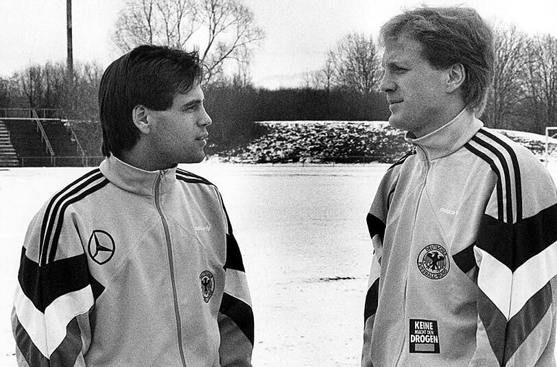 Ulf Kirsten und Matthias Sammer (rechts), der heutige Sportvorstand des FC Bayern. Die ehemaligen DDR-Nationalspieler unterhalten sich am 18. Dezember 1990 beim Training in Stuttgart, wo die deutsche Nationalelf tags darauf in einem Freundschaftsspiel gegen die Schweiz antritt und mit 4:0 gewinnt. Erstmals stehen frühere DDR-Akteure in der DFB-Elf - darunter auch Sammer, Kirsten kommt noch nicht zum Einsatz.