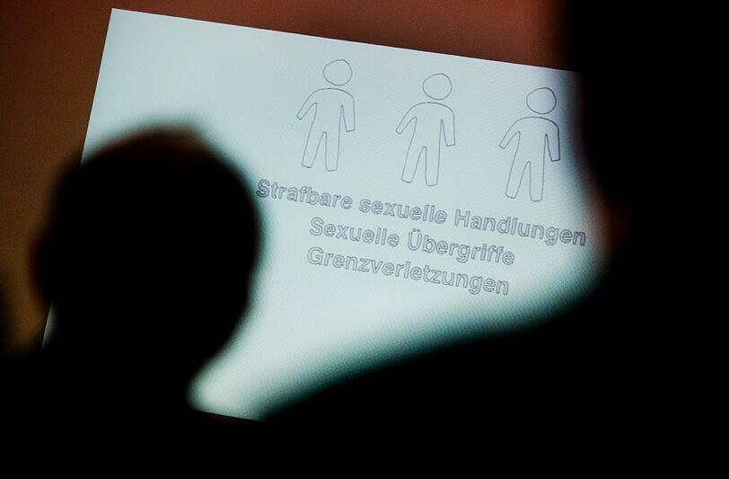 Tagungsteilnehmer betrachten bei einer Fachtagung des Bistums Hildesheim zur Prävention von sexuellem Missbrauch in der Kirche. Foto: Julian Stratenschulte/Illustration