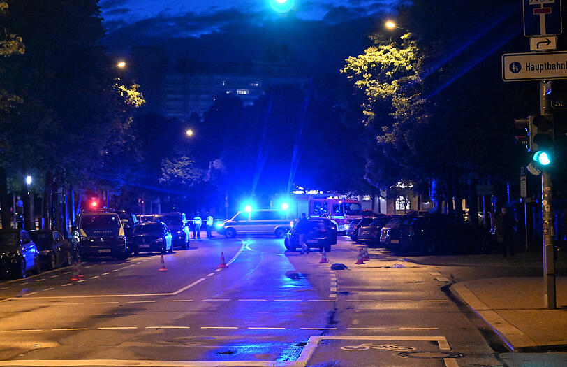 Polizisten stehen auf der Straße. An der Theresienwiese in München hat es einen Schusswaffeneinsatz der Polizei gegeben.