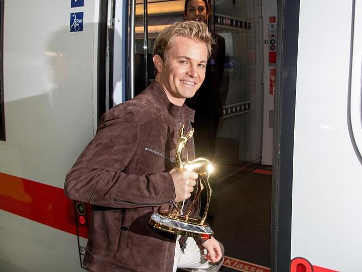 Nico Rosberg, früherer Autorennfahrer, steigt am Münchner Hauptbahnhof in einen ICE und hält dabei einen Bambi in der Hand. Foto: Tobias Hase