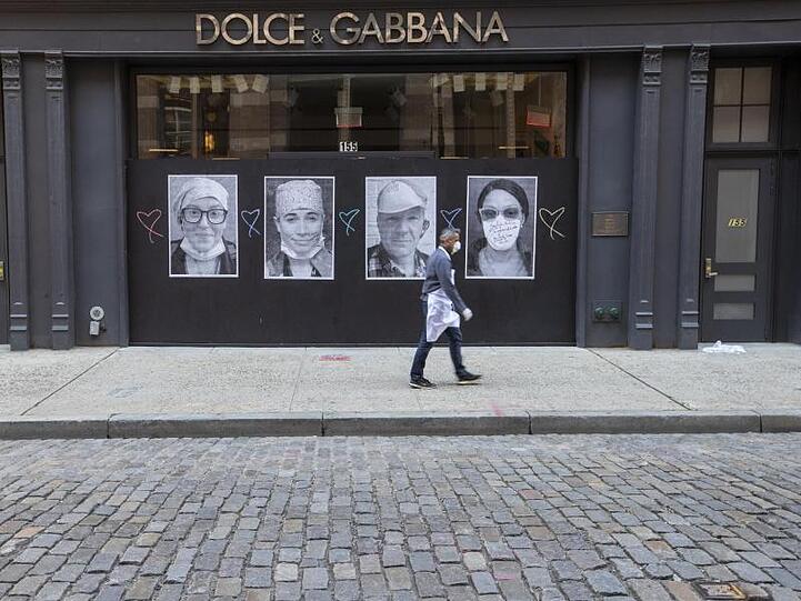 Ein Mann mit Mundschutz geht an einer geschlossenen Boutique in New York vorbei.
