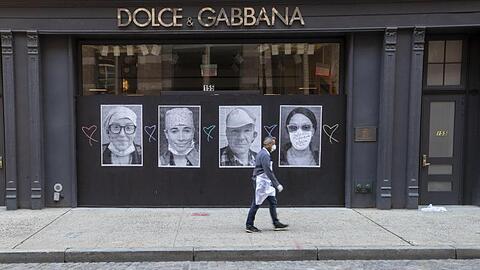 Ein Mann mit Mundschutz geht an einer geschlossenen Boutique in New York vorbei.