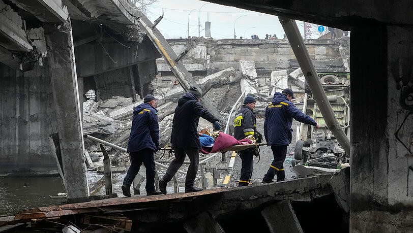 Irpin: Ukrainische Rettungskräfte bergen eine ältere Frau unter einer zerstörten Brücke. Irpin: Ukrainische Rettungskräfte bergen eine ältere Frau unter einer zerstörten Brücke.