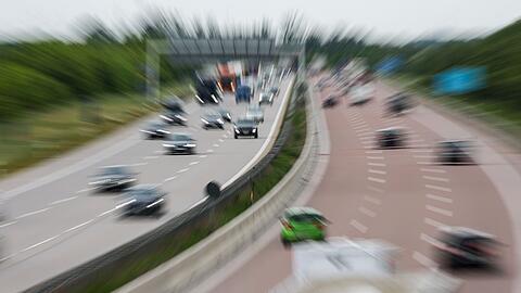 Zahlreiche Autos und Lastwagen fahren auf einer Autobahn.