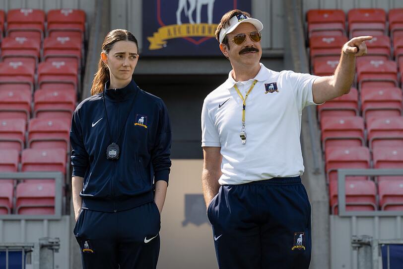 Ted Lasso (Jason Sudeikis) ist zur&uuml;ck: Dass ausgerechnet ein Mann die Lady Greyhounds trainiert, findet Alice Chilton(Tanya Reynolds) allerdings nicht so prickelnd.