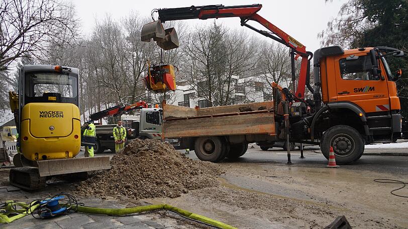Mitarbeiter der Stadtwerke flicken das Loch in der Straße. Zuvor lief ordentlich Wasser auf die Fahrbahn.