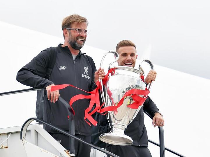 Jürgen Klopp und Jordan Henderson kommen mit der Trophäe am John Lennon Flughafen in Liverpool an.