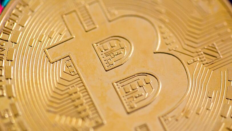Eine Bitcoin-Münze liegt auf einem Tisch. (Symbolbild)