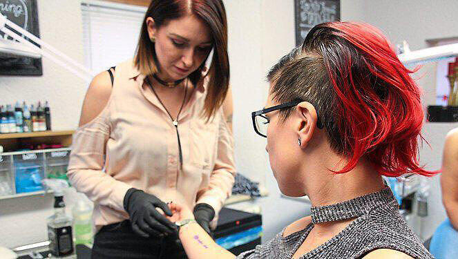 Die Tätowiererin begutachtet die Tattoo-Vorlage auf Danielas Unterarm. Die Tätowiererin begutachtet die Tattoo-Vorlage auf Danielas Unterarm.