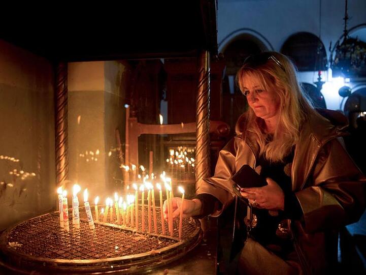 Weihnachten in Bethlehem: Eine Besucherin zündet eine Kerze in der Geburtskirche an.