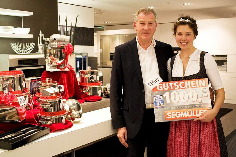 1000 Euro und all die teuren Kochgeräte im Hintergrund überreicht Segmüller-Gesamtvertriebschef Reinhold Gütebier der Siegerin.
