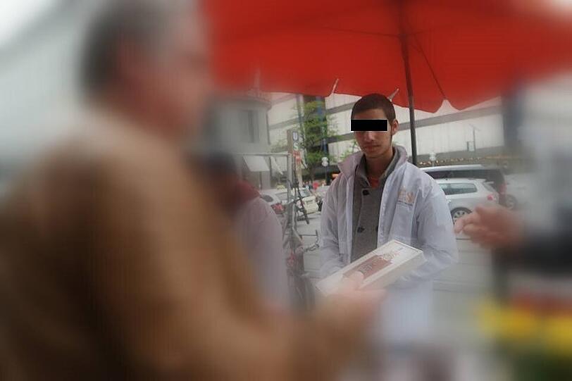 Erkan (14) verteilt Ausgaben des Koran an einem &bdquo;Lies&ldquo;-Stand am Münchner Stachus.