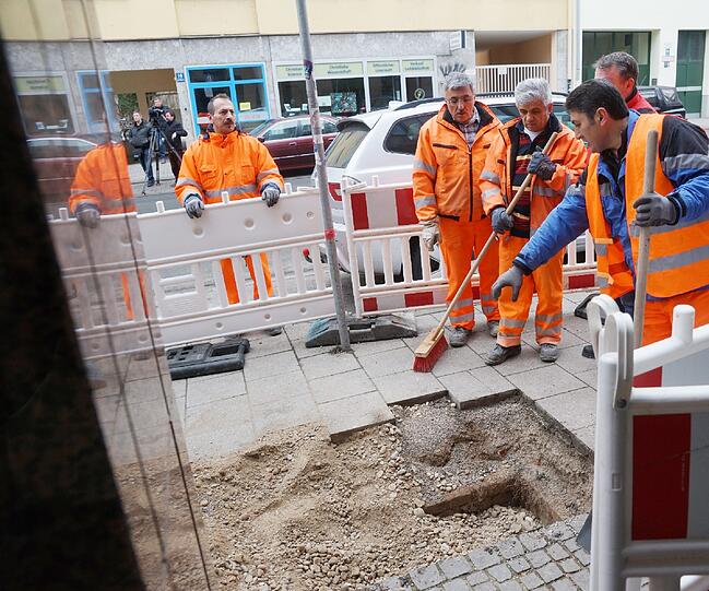 Mitarbeiter des Baureferats verfüllen den Schacht mit Kies und Beton.