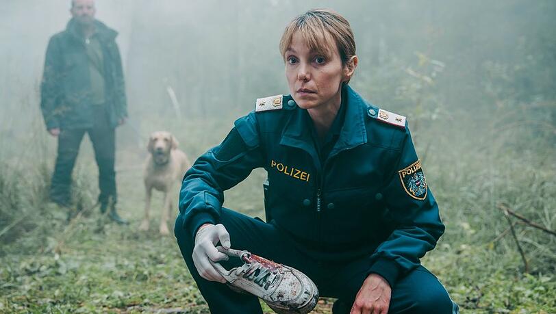 "Das Vergessen: Spurlos im Moor": Polizistin Pia Krauss (Julia Koschitz) h&auml;lt einen blutverschmierten Turnschuh in der Hand, der m&ouml;glicherweise der Vermissten geh&ouml;rt.
